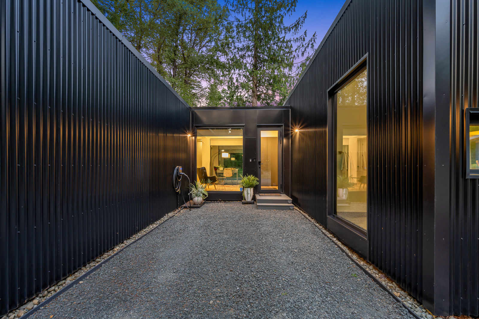 Illuminated corridor between the wings of the main residence at twilight