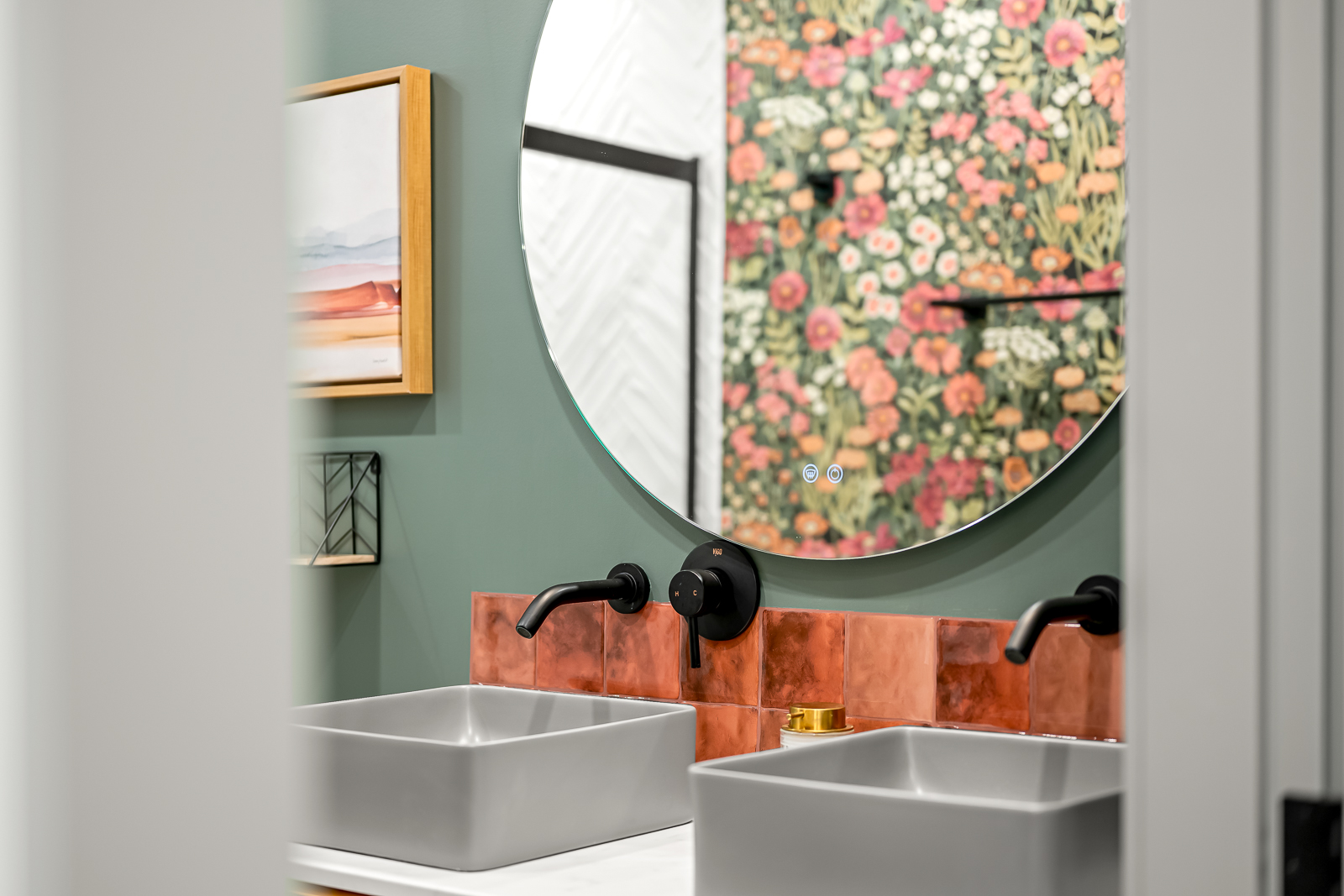 Bathroom with dual vessel sinks, sage green wall, copper tile, and black fixtures